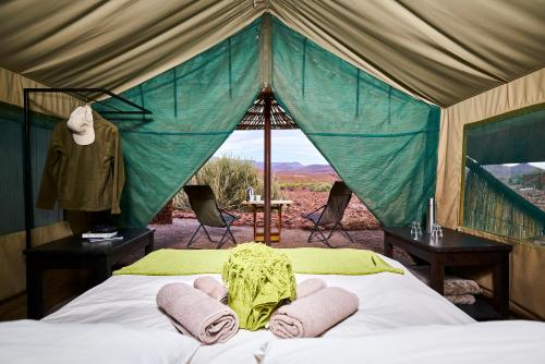 a bedroom with a bed in a tent at Etendeka Mountain Camp in Damaraland