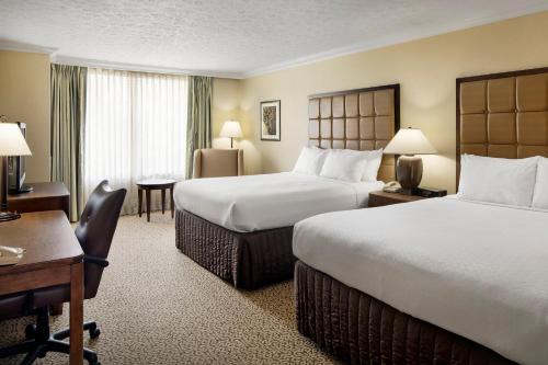 a hotel room with two beds and a desk at Crowne Plaza Louisville Airport Expo Center, an IHG Hotel in Louisville