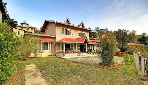 ein großes Haus mit einem Zaun davor in der Unterkunft Neelesh Inn- A Luxury Lake View Hotel- 20 kms from Nainital in Bhīm Tāl