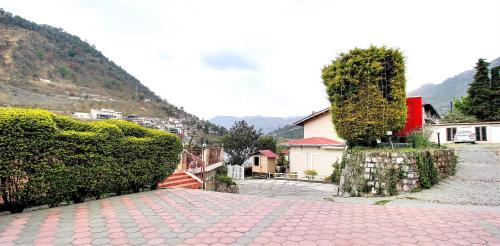a cobblestone street with a house and a hill at Neelesh Inn- A Luxury Lake View Hotel- 20 kms from Nainital in Bhīm Tāl