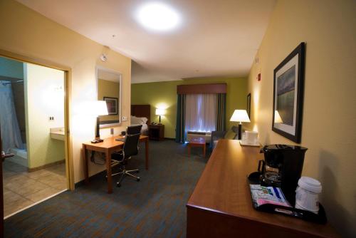 a hotel room with a desk and a room at Holiday Inn Express Hotel & Suites Atlanta East - Lithonia by IHG in Lithonia