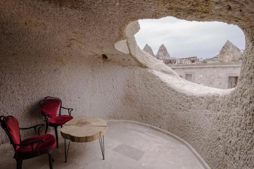a room with two chairs and a table and a window at Lunar Cappadocia Hotel in Goreme