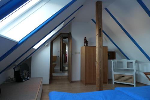 um quarto com um telhado azul com uma cama e uma televisão em "Haus am Deich" em Cuxhaven