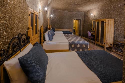 a hotel room with four beds with blue pillows at Lunar Cappadocia Hotel in Goreme