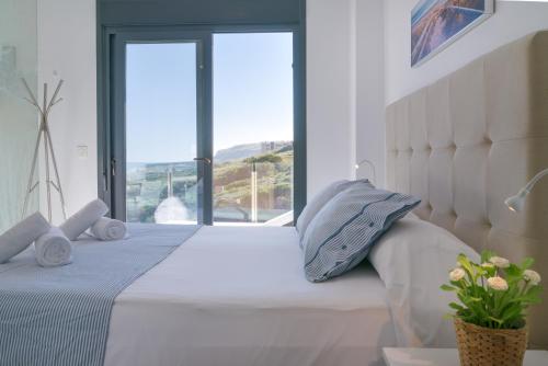 ein Schlafzimmer mit einem weißen Bett mit einem großen Fenster in der Unterkunft Myflats Luxury Sea Coast in Arenales del Sol