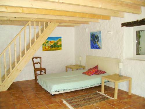 - une chambre avec un lit et un escalier en bois dans l'établissement Tremoyec, à Surzur