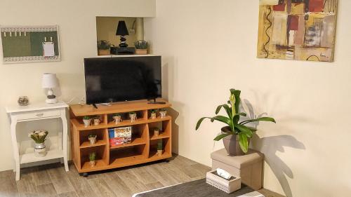 康采姆的住宿－Le Familial，客厅配有台面上的平面电视
