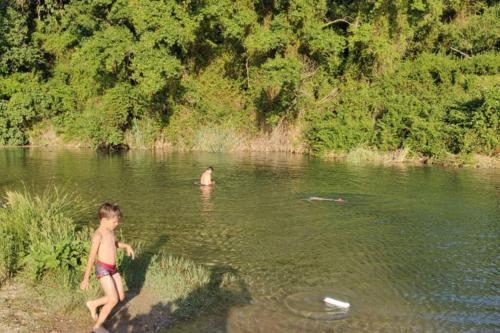 a young boy standing in a river with a frisbee at Casa Rural Adriana, Montanejos in Montanejos