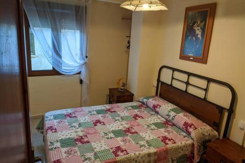 een slaapkamer met een bed met een quilt bij Casa Rural Adriana, Montanejos in Montanejos