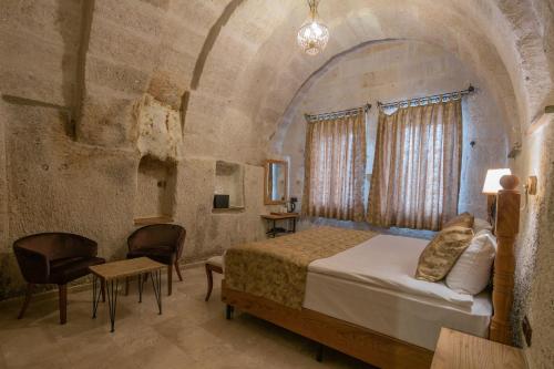 a bedroom with a bed and a table and chairs at Lunar Cappadocia Hotel in Goreme