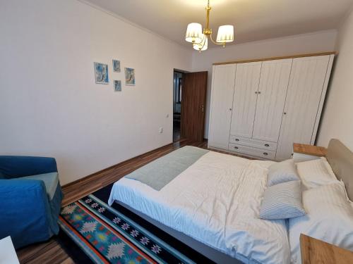 a bedroom with a large bed and a blue couch at Charming apartment in villa in Iaşi