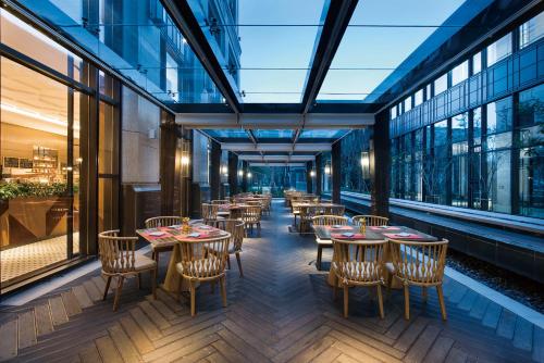 a restaurant with tables and chairs and windows at Crowne Plaza Shanghai Pujiang by IHG in Shanghai