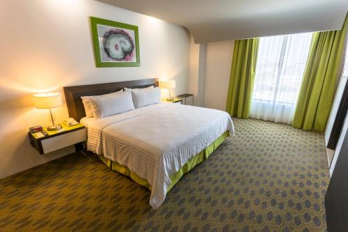 a hotel room with a bed and a window at Holiday Inn Queretaro Zona Krystal by IHG in Querétaro