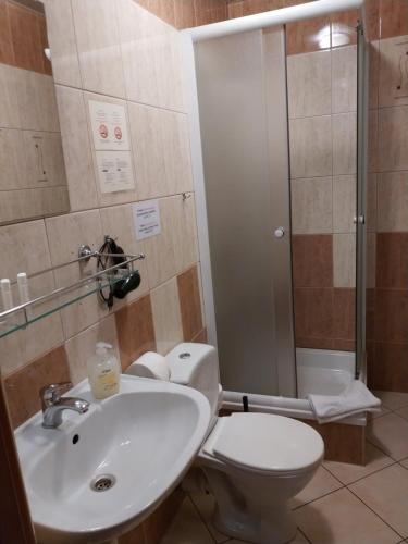 a bathroom with a toilet and a sink and a shower at Hotel Górsko in Wieliczka