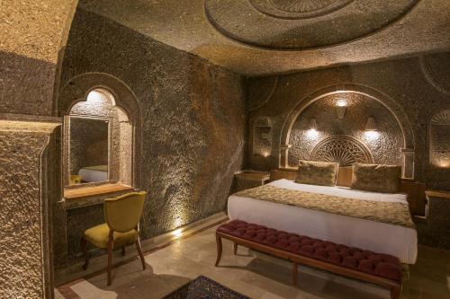a bedroom with a bed and a mirror and a chair at Lunar Cappadocia Hotel in Goreme
