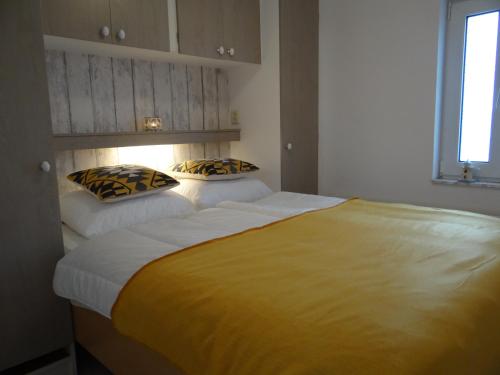 een slaapkamer met een groot bed met 2 kussens erop bij Vakantiewoning Akkerrand Kamperland in Kamperland
