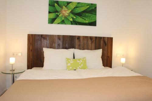 1 dormitorio con 1 cama con cabecero de madera en Kaiser Wilhelm - Appartement mit Saunanutzung, en Burgbernheim