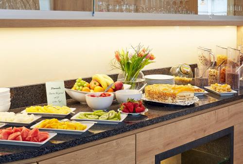 a buffet of fruits and vegetables on a counter at Hotel & Ferienappartements Edelweiss in Willingen