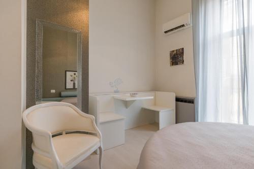 Habitación blanca con silla y espejo en Sunny Home, en Verona