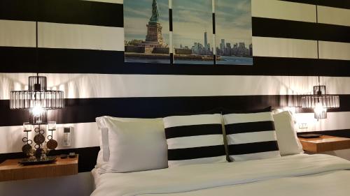 a bed with black and white pillows and the statue of liberty at Italy Condotel Darasa in Tanauan