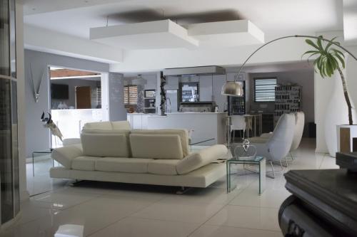 un soggiorno con divano bianco e tavolo di Luxury Upmarket Guesthouse 20 on 4th a Rustenburg