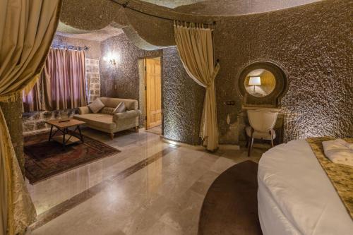 a bedroom with a bed and a couch in a room at Lunar Cappadocia Hotel in Goreme