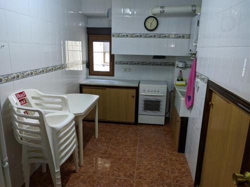 a kitchen with a table and chairs and a clock at Casa Rural Adriana, Montanejos in Montanejos