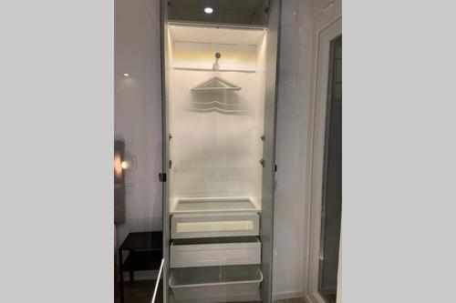 a glass closet with shelves and hangers in it at Moderno y funcional apartamento en el centro-El rastro in Madrid