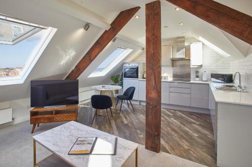 a kitchen and living room with a tv and a table at Host & Stay - The Penthouse, Hudsons Yard House in Whitby