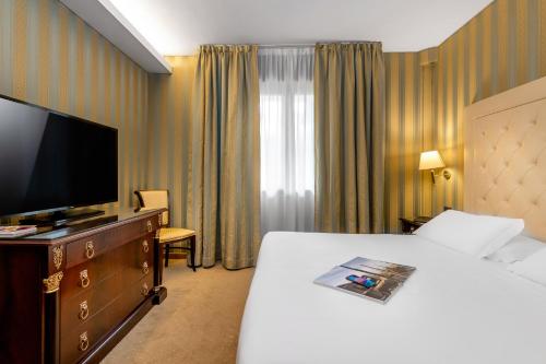 a hotel room with a bed and a flat screen tv at Best Western Cavalieri Della Corona in Cardano al Campo