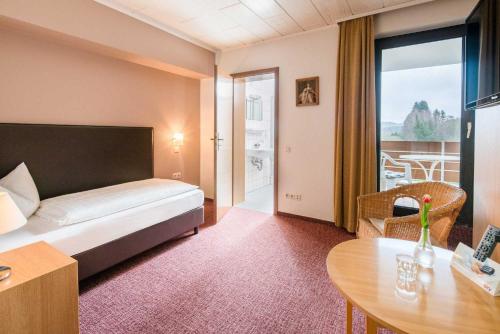 DeudesfeldにあるPension Haus Annyのベッドとテーブルが備わるホテルルームです。