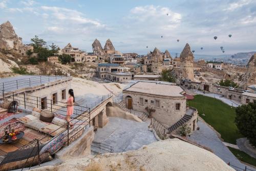 a woman standing on a balcony overlooking a city at Lunar Cappadocia Hotel in Goreme