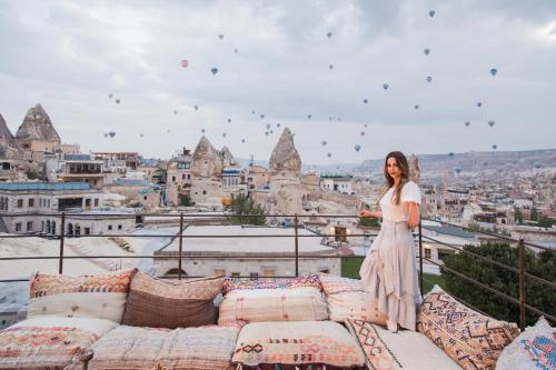 a woman in a white dress standing on a balcony at Lunar Cappadocia Hotel in Goreme