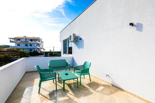 a patio with chairs and a table on a balcony at Vila Enxhi in Ksamil