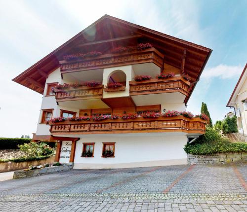 un edificio blanco con balcones y flores. en Hotel Haus Seehang, en Constanza