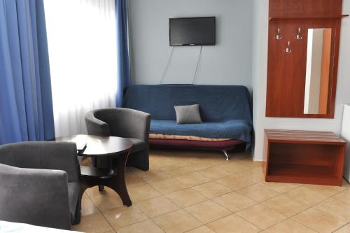 sala de estar con sofá azul y sillas en Hotel Elda 2, en Bydgoszcz