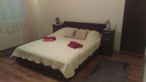 a bedroom with a large bed with two red pillows at APARTMAN RITA in Vinkovci