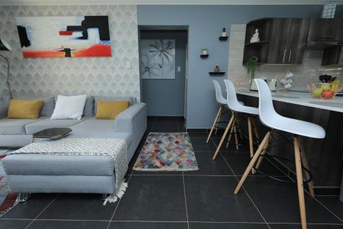 een woonkamer met een bank en een keuken bij The View - Luxury Apartment in Witbank