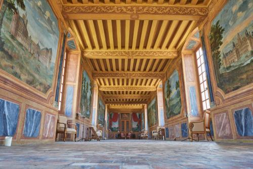 a large room with paintings on the walls at Chambres d'hôtes au Château de Gizeux in Gizeux