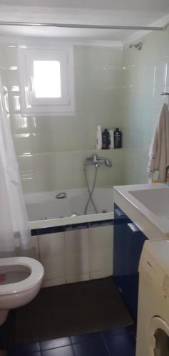 a white bathroom with a sink and a toilet at Cozy Penthouse in Thessaloniki