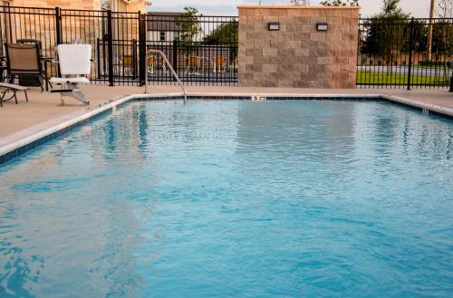 a swimming pool with blue water in front of a fence at Holiday Inn Express & Suites Taylor by IHG in Taylor