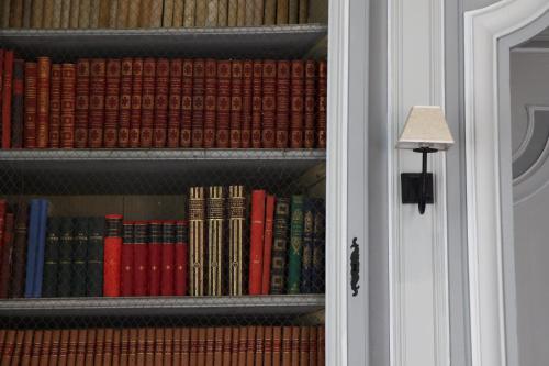 a book shelf filled with lots of books next to a door at Chambres d'hôtes au Château de Gizeux in Gizeux