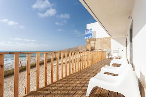 a balcony with a view of the beach at Blue Buddha Beach Rooms & Suites in Ericeira