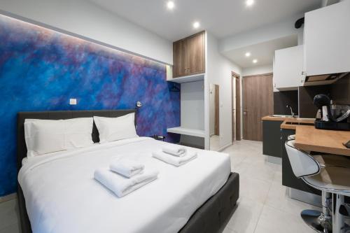 a bedroom with a large white bed and a kitchen at DK Mini Studio White Tower in Thessaloniki