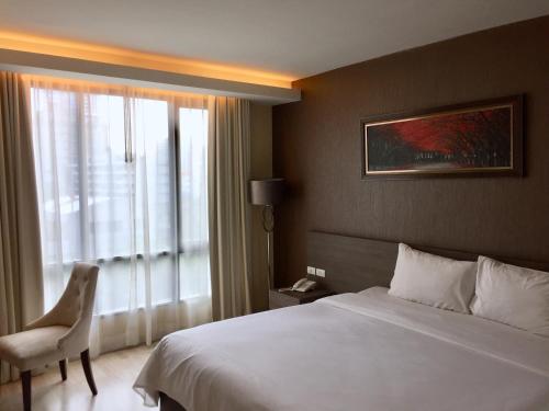 Un pat sau paturi într-o cameră la Avatar Suites Hotel - SHA Extra Plus