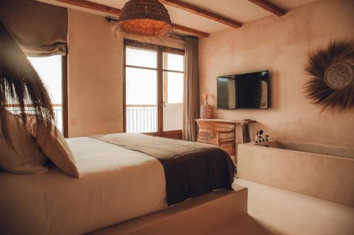 
a hotel room with a bed and a tv at Nomad Hotel - Xábia Port in Jávea
