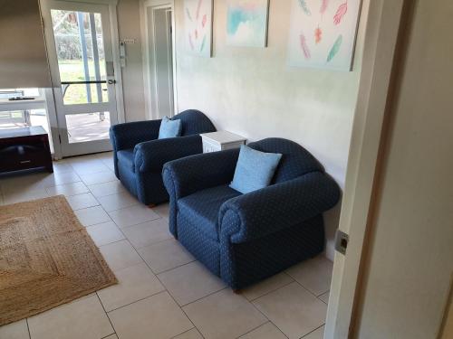 - deux chaises bleues assises dans le salon dans l'établissement Denison Lodge, à Mudgee