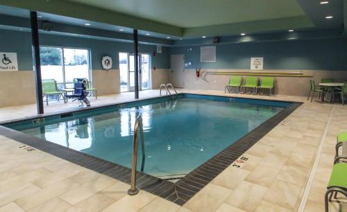 a large swimming pool in a gym with green chairs at Holiday Inn Express & Suites Nashville North - Springfield by IHG in Springfield