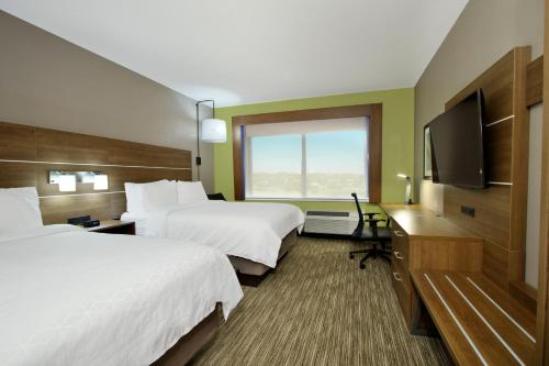 a hotel room with two beds and a flat screen tv at Holiday Inn Express & Suites Dallas Frisco NW Toyota Stdm by IHG in Frisco