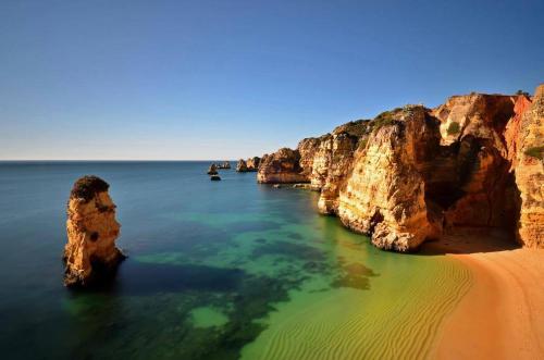 a view of a beach with rocks in the water at HENRI'S APARTMENTS - Pátio do Convento in Lagos